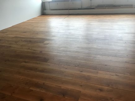 Foto de la instalación de un parquet hecha en un despacho de alto estánding por Comparquets